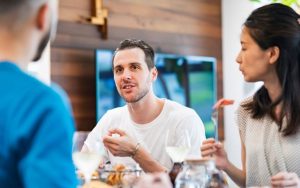 Friends in serious conversation while eating dinner 