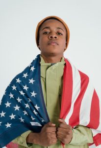 Young black man wrapped in the American flag