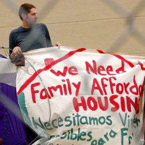 Man holding sign at affordable housing protest